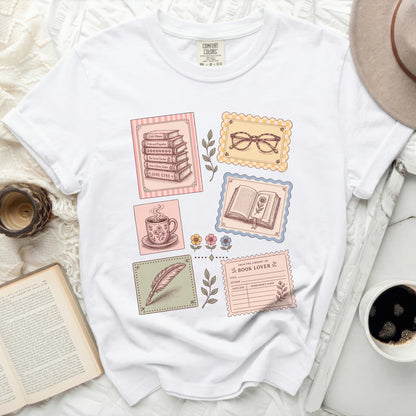 T-shirt with books, teacup, feather, and library card graphic.