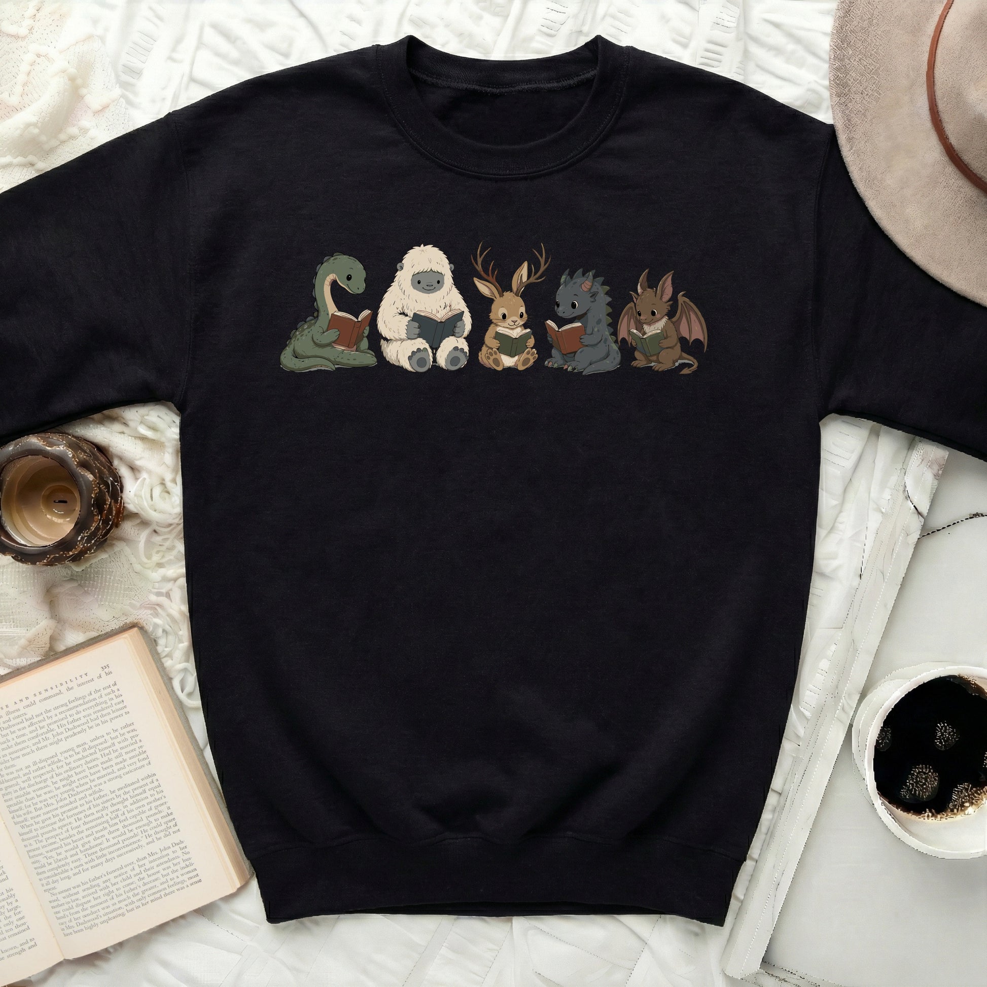Black sweatshirt with cartoon monsters reading books print.