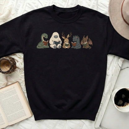 Black sweatshirt with cartoon monsters reading books print.