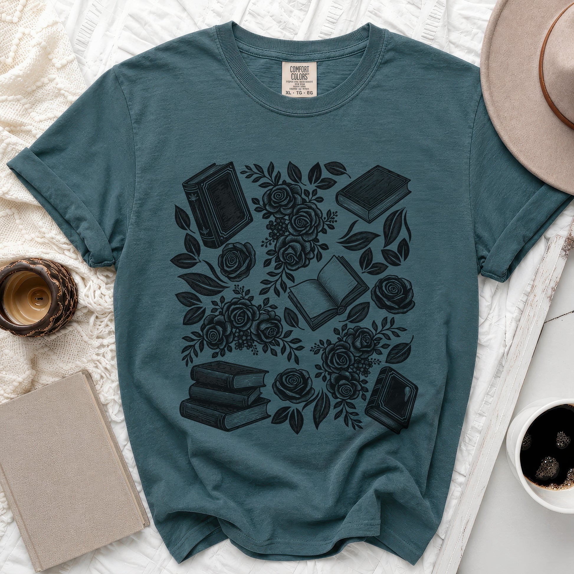 Teal t-shirt with black book and rose pattern, "Comfort Colors" tag visible.