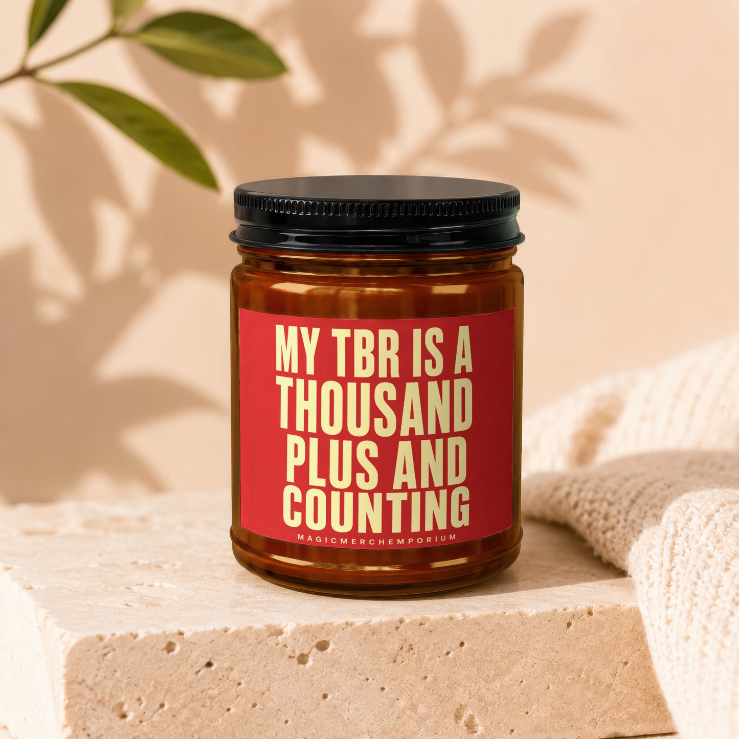 Brown glass candle with red label saying "MY TBR IS A THOUSAND PLUS AND COUNTING".
