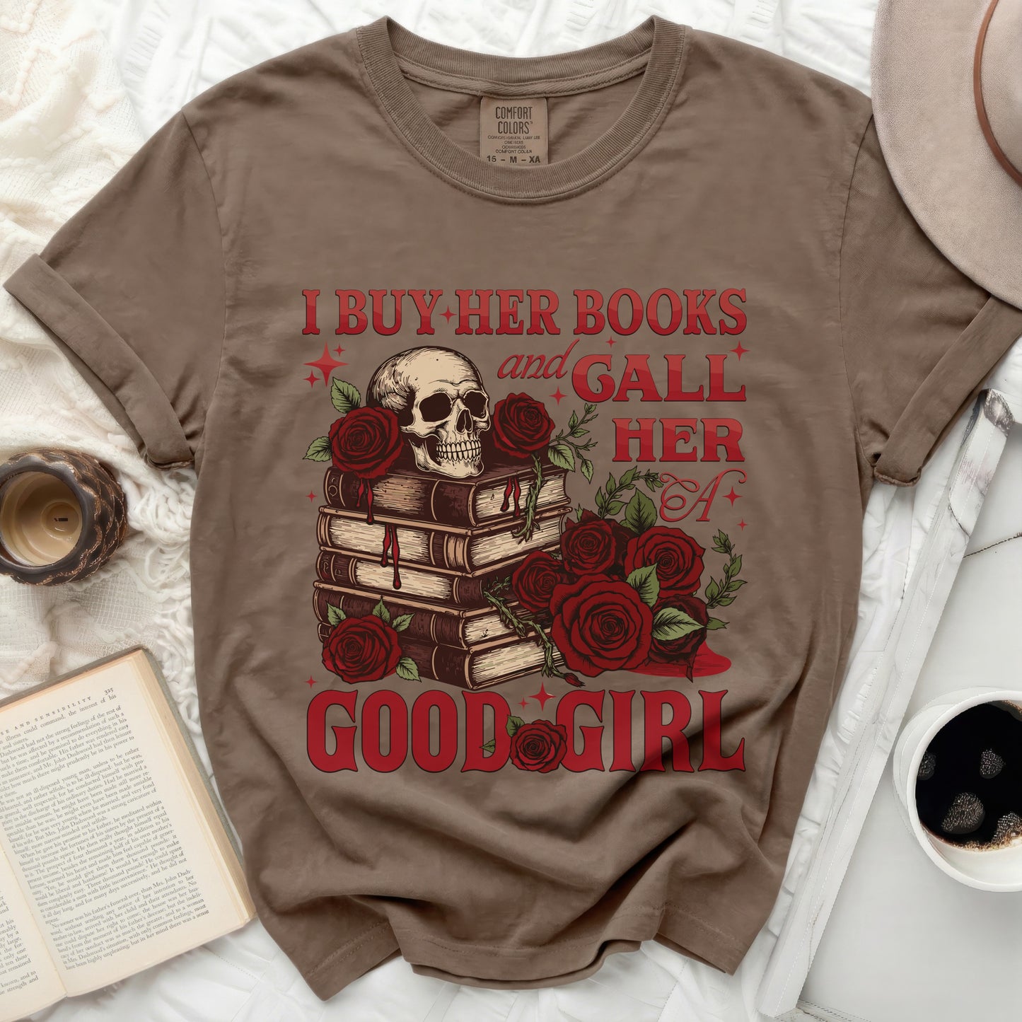 Brown t-shirt with skull, books, roses, and text "I BUY HER BOOKS and GALL HER A GOOD GIRL".