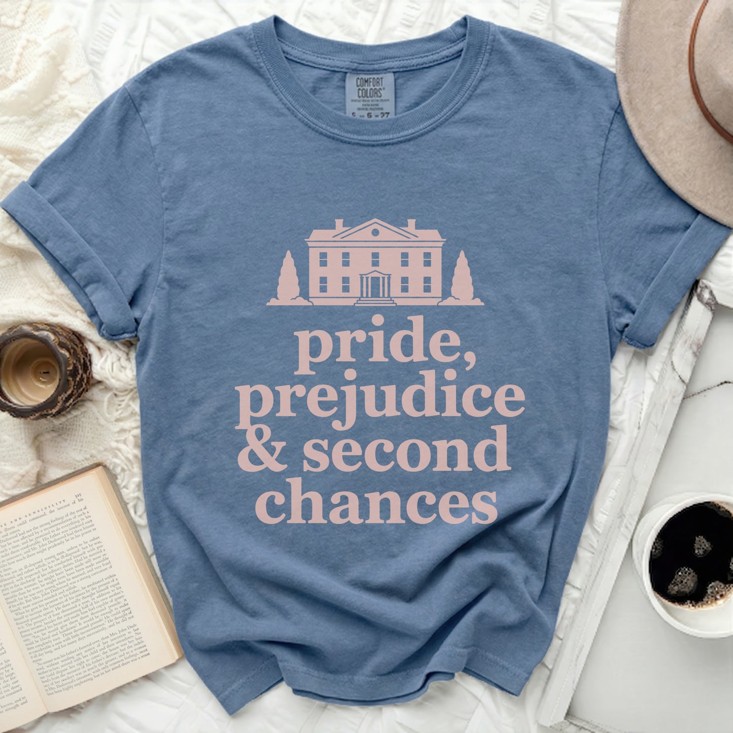 Blue t-shirt with house graphic and text "pride, prejudice & second chances".