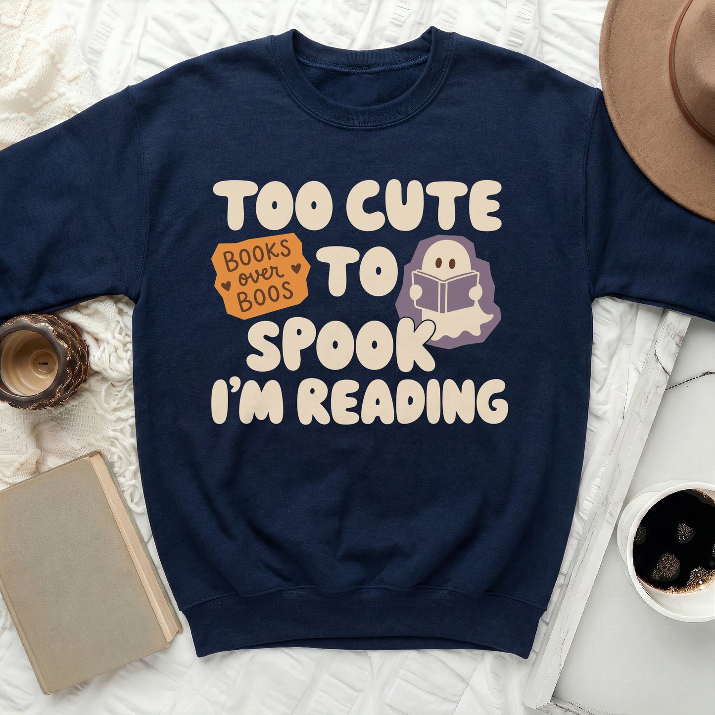 Navy sweatshirt with text "Too cute to spook. I'm reading" and a ghost reading a book.