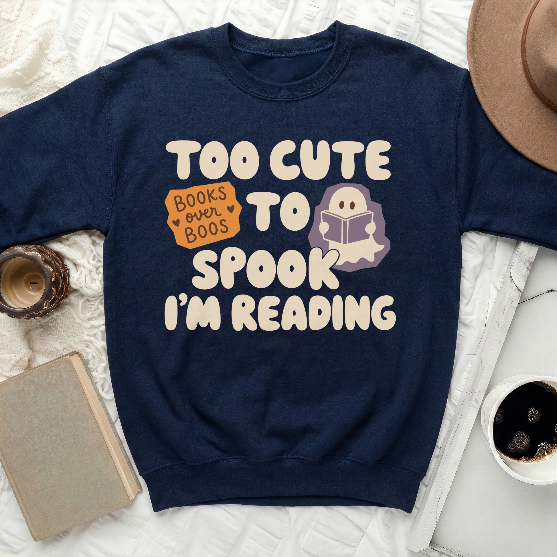 Navy sweatshirt with text "Too cute to spook. I'm reading" and a ghost reading a book.