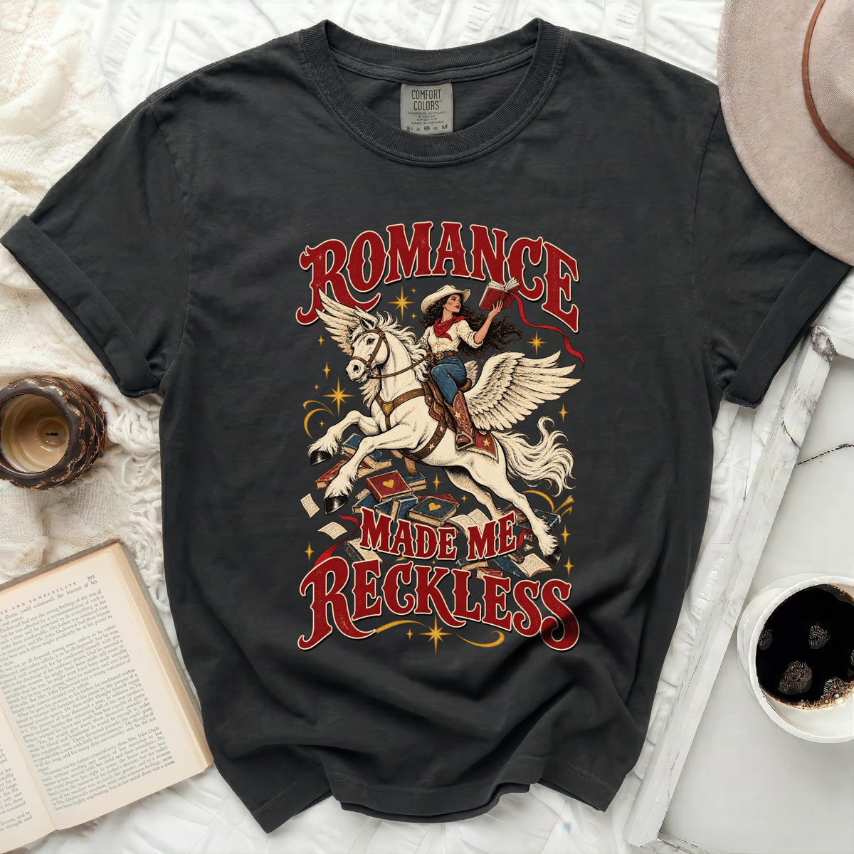 Dark t-shirt with "Romance Made Me Reckless" text and winged horse graphic.