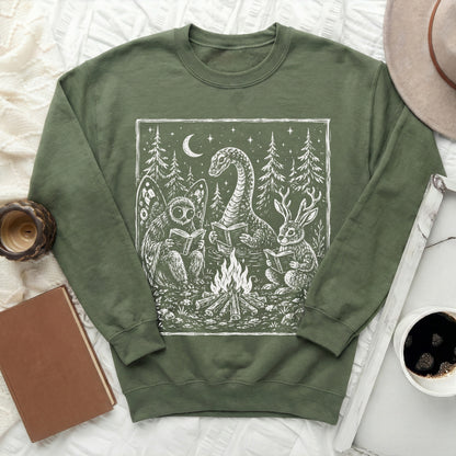 Green sweatshirt with white linocut art of fantasy creatures reading by campfire.