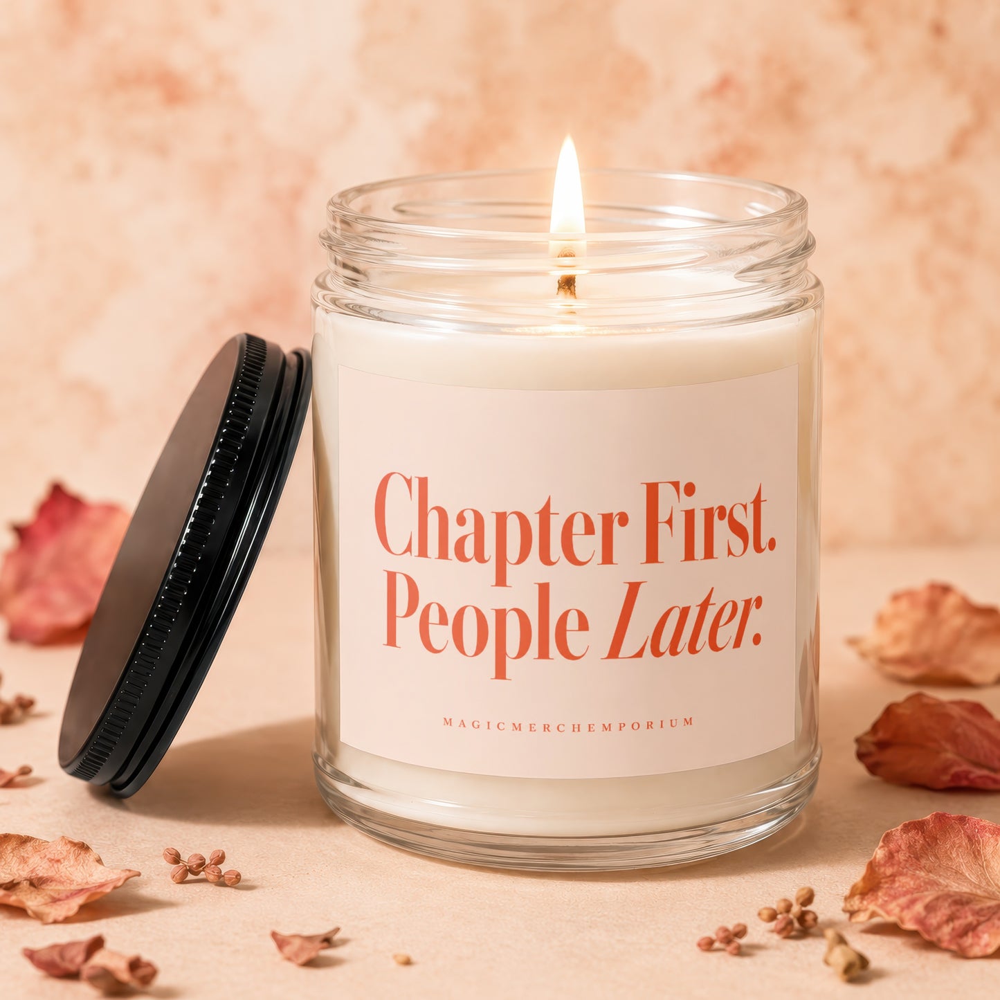 Candle with lit wick and black lid, reads "Chapter First. People Later."