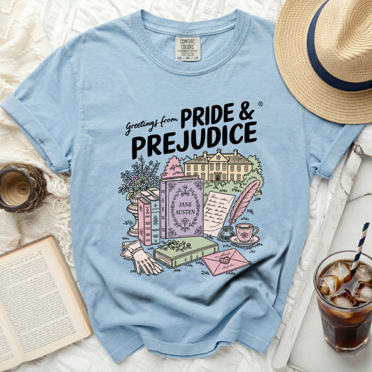 Light blue t-shirt with "Greetings from PRIDE & PREJUDICE" and an illustration.