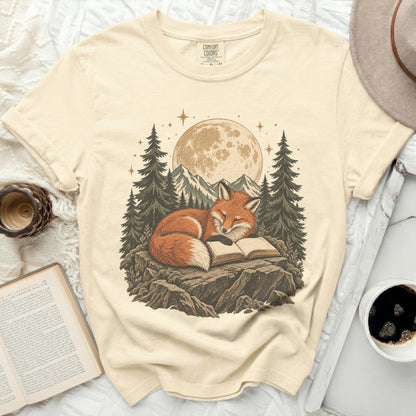Cream t-shirt with a graphic of a fox reading a book under the moon.