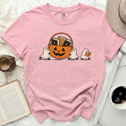 Pink t-shirt with cartoon ghosts carrying a pumpkin basket filled with books.