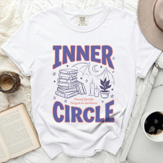 White t-shirt with purple text "INNER CIRCLE" and graphic elements.