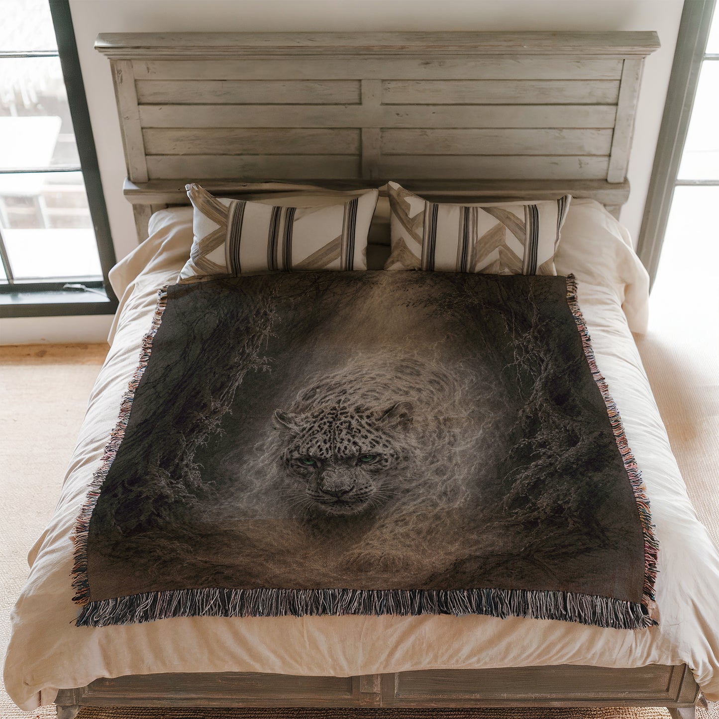 a bedroom with a bed featuring a large blanket with a leopard print design. The bed has a wooden headboard and white bedding.