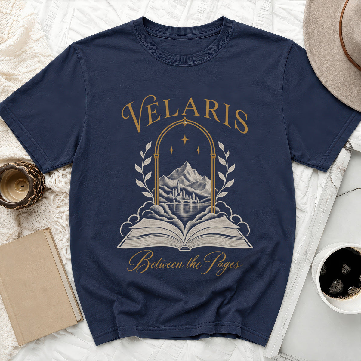 Navy t-shirt with "Velaris Between the Pages" text and an open book illustration.