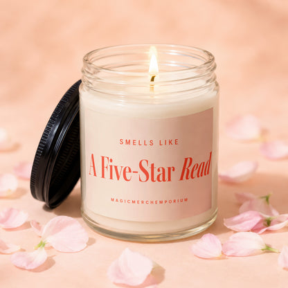 Candle with lit wick and black lid, reading "Smells Like A Five-Star Read".