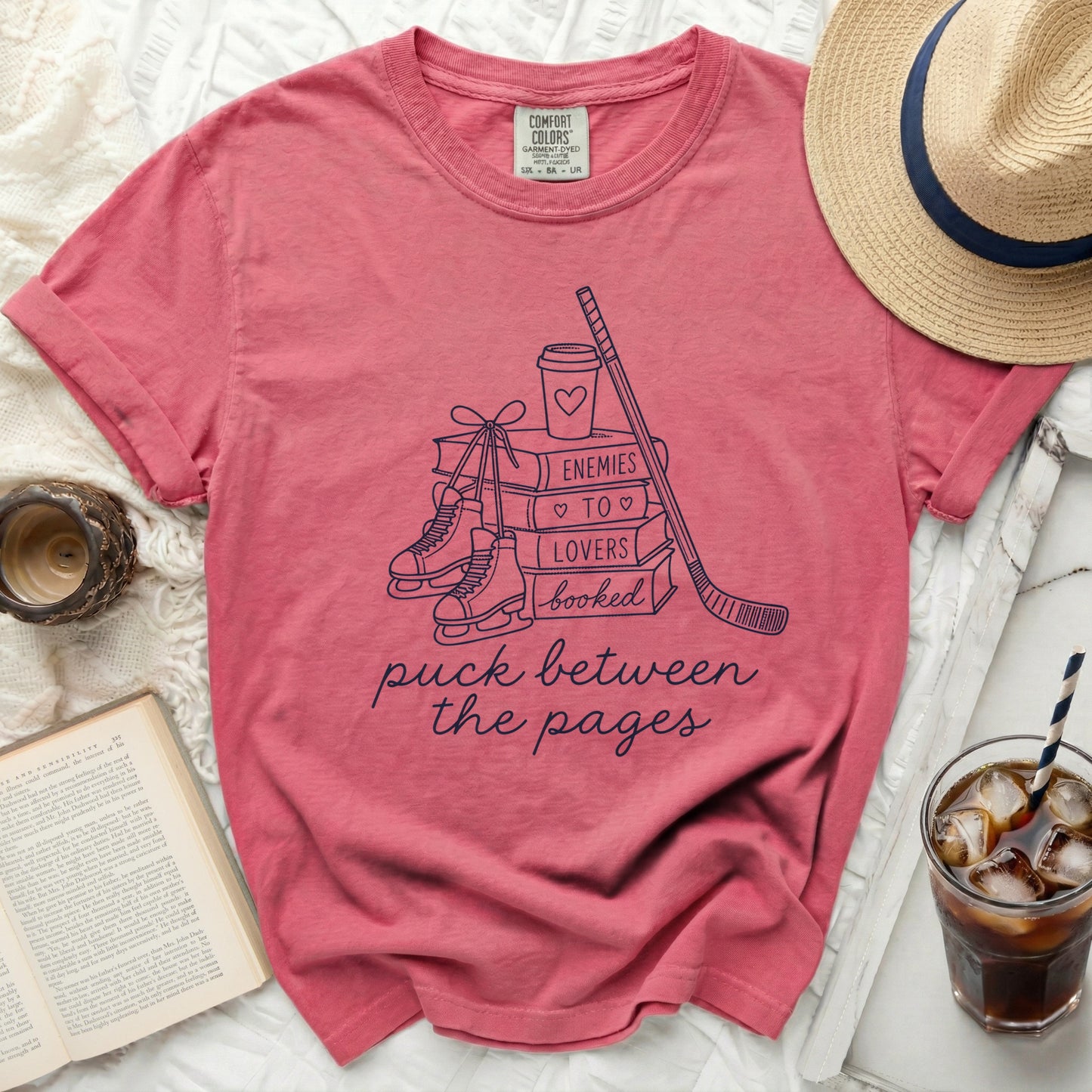 T-shirt with "puck between the pages" text and book, hockey, and ice skate graphics.