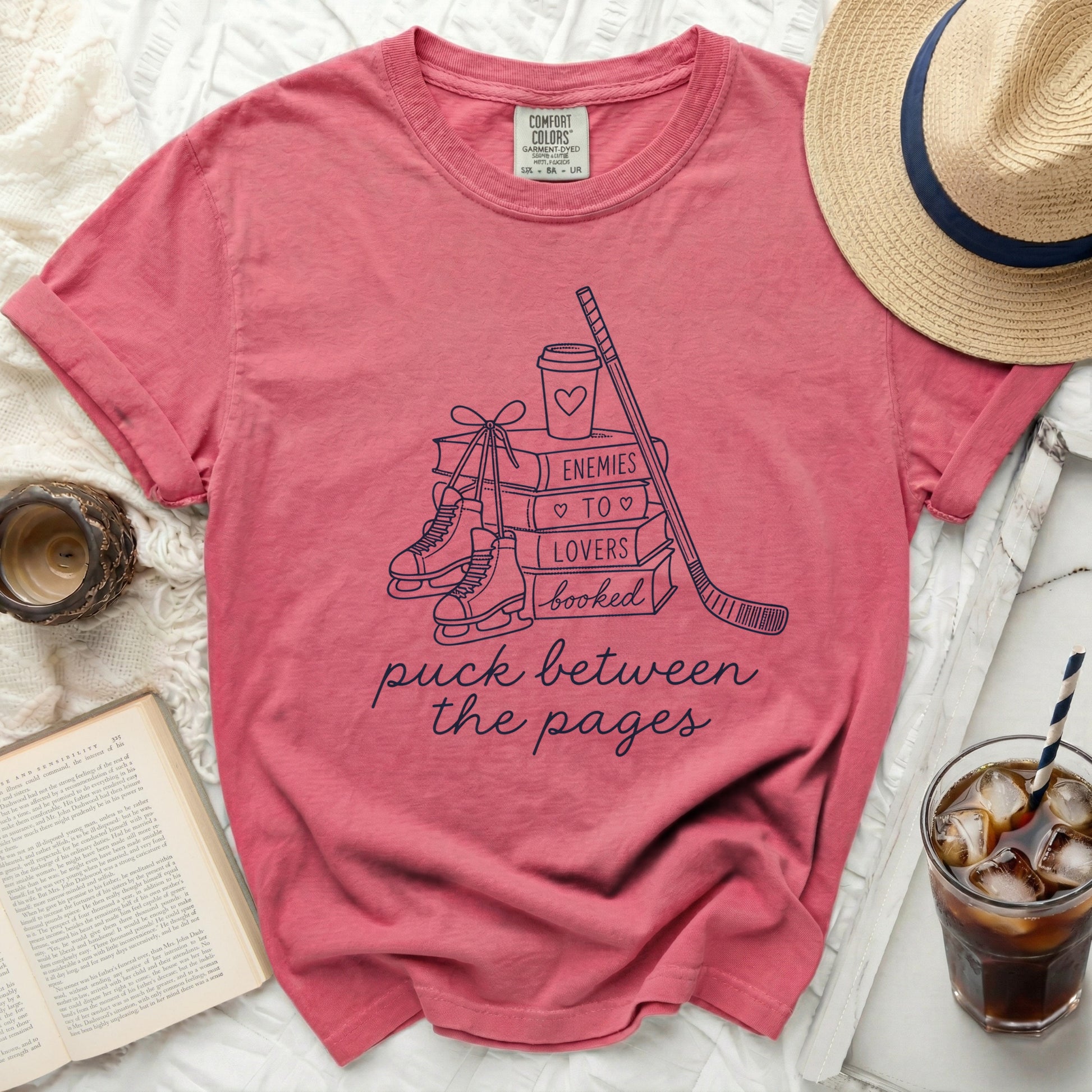 T-shirt with "puck between the pages" text and book, hockey, and ice skate graphics.