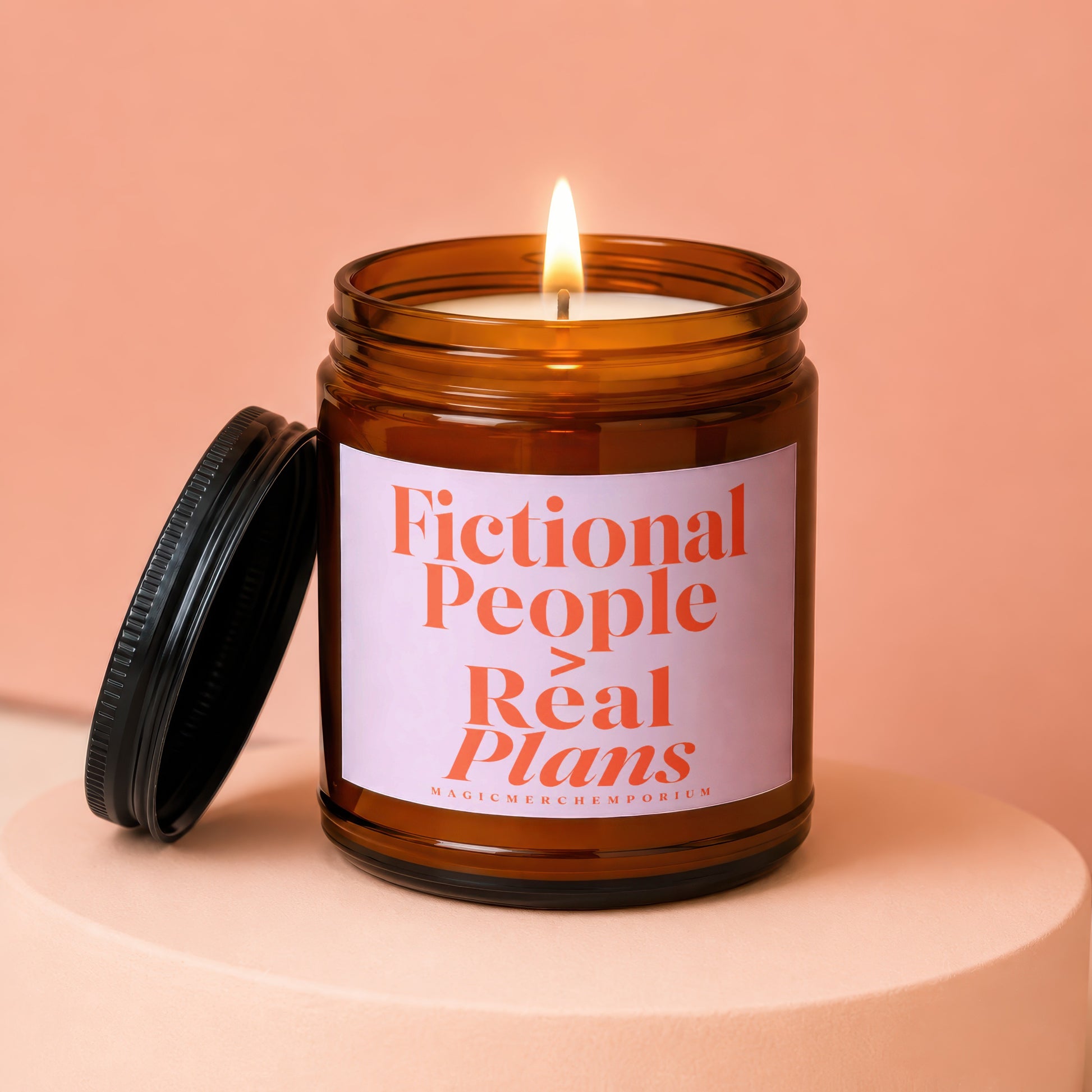 Amber jar candle with lit wick and lid nearby reads "Fictional People Real Plans."