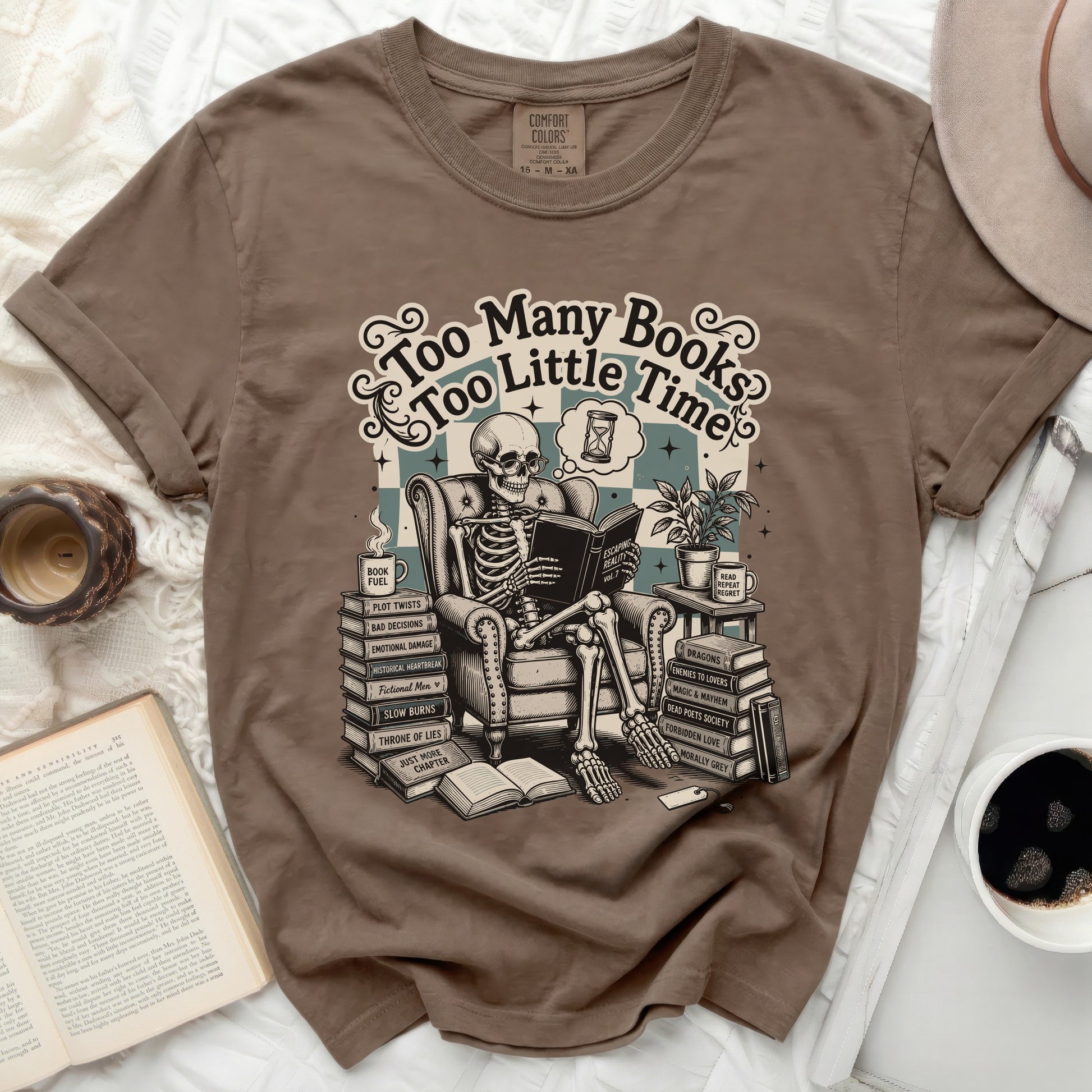 Brown t-shirt graphic of a skeleton reading "Too Many Books Too Little Time" with stacks of books.