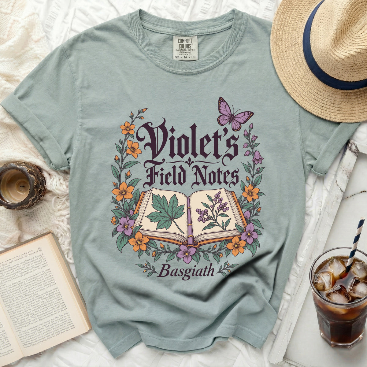 Dusty blue t-shirt with "Violet's Field Notes Basgiath" text and floral design.