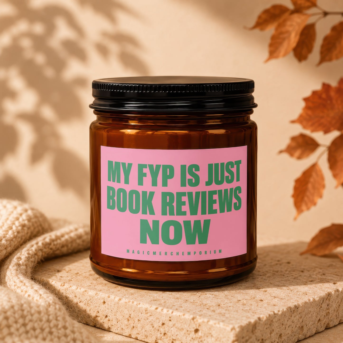 Amber jar candle with pink label stating "MY FYP IS JUST BOOK REVIEWS NOW."