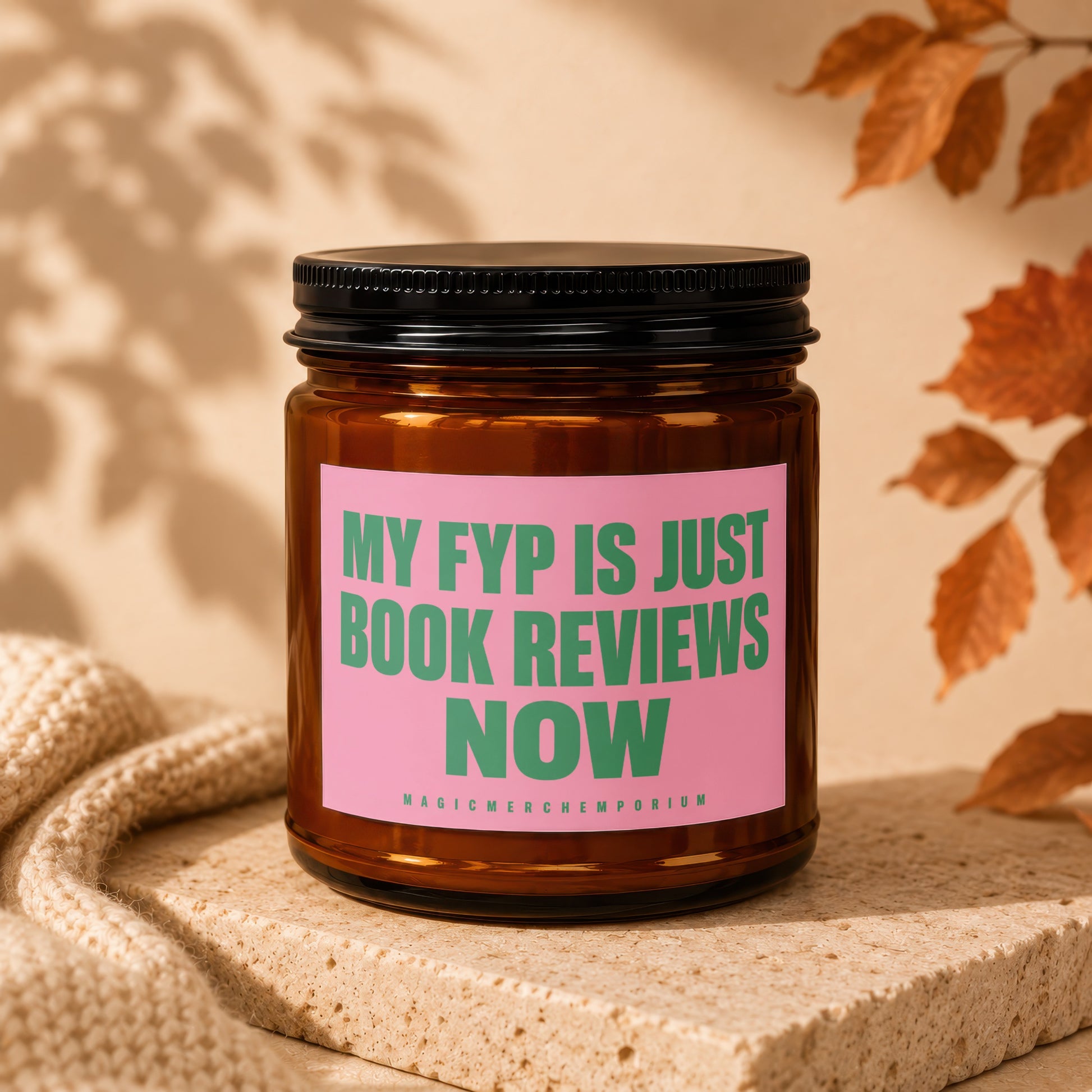 Amber jar candle with pink label stating "MY FYP IS JUST BOOK REVIEWS NOW."