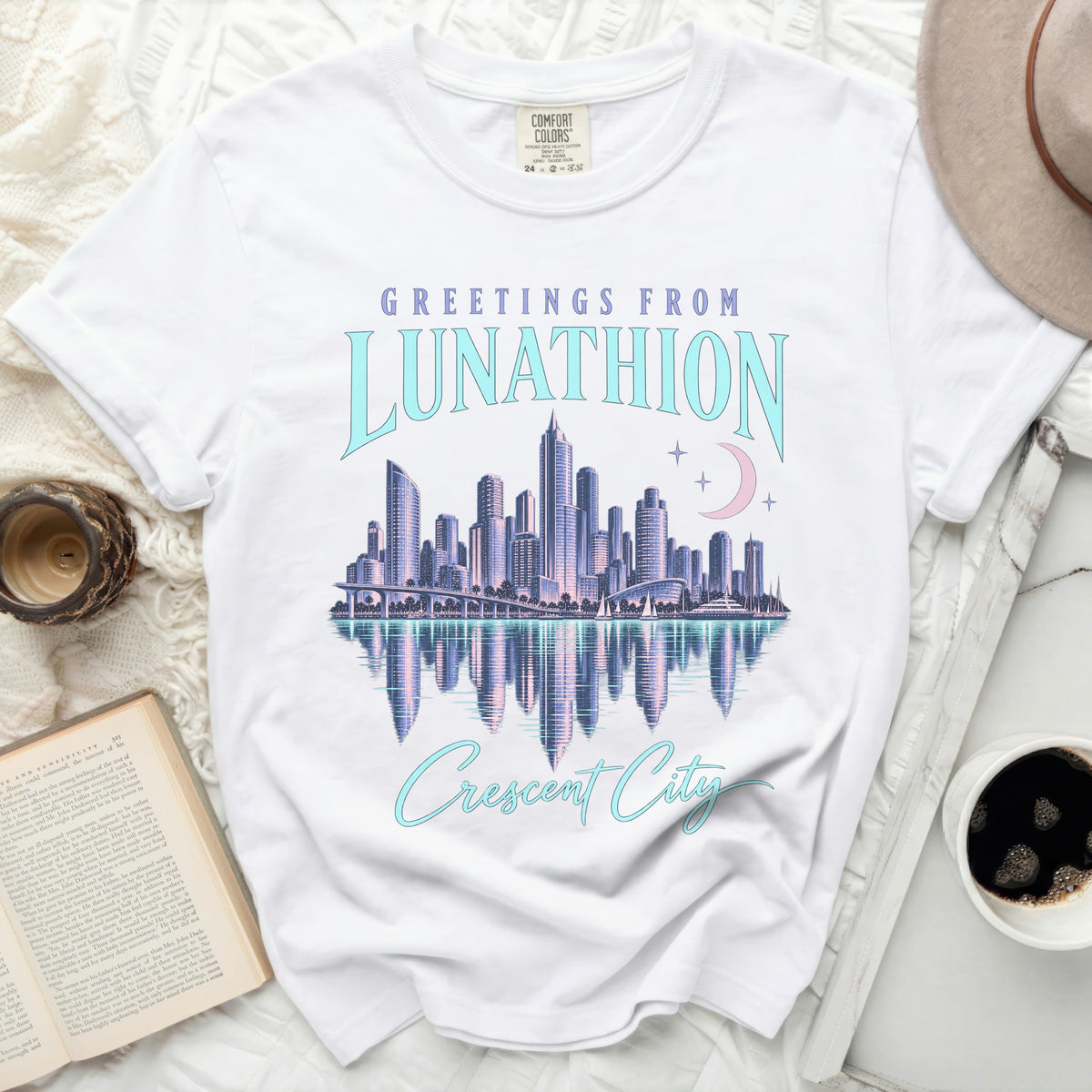 White t-shirt with "Greetings from Lunathion Crescent City" graphic featuring a cityscape.