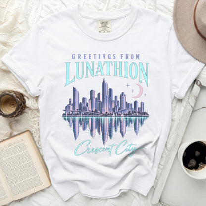 White t-shirt with "Greetings from Lunathion Crescent City" graphic featuring a cityscape.