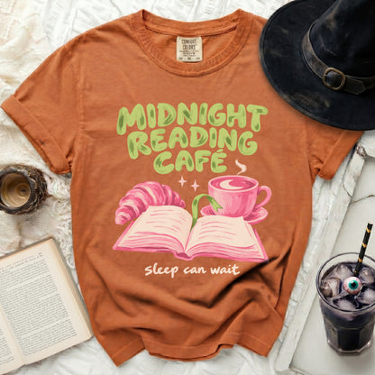 Orange t-shirt with "Midnight Reading Cafe" and a book, croissant, and coffee.