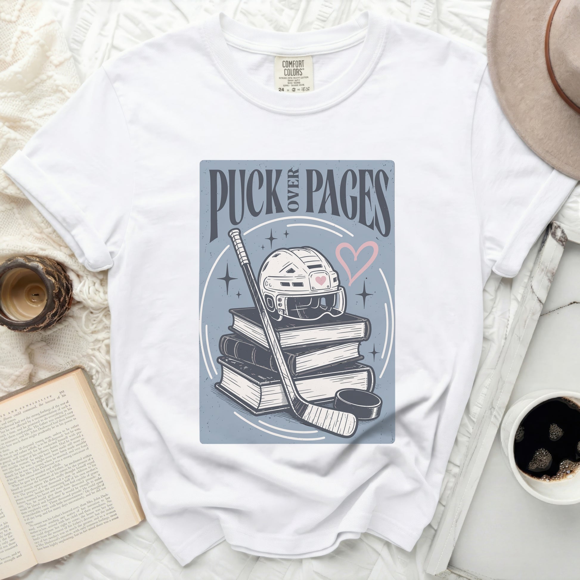 White t-shirt with "Puck & Pages" text, hockey puck, and books graphic.