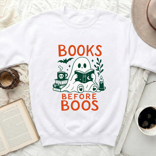 White sweatshirt with "BOOKS BEFORE BOOS" and a ghost reading a book graphic.
