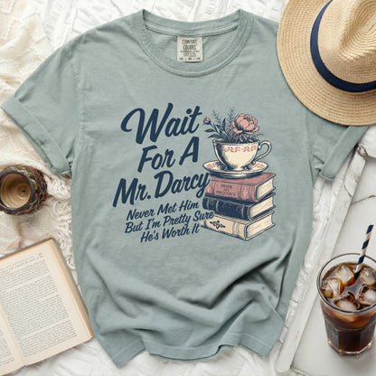 Tea cup and books graphic with text "Wait For A Mr. Darcy Never Met Him But I'm Pretty Sure He's Worth It".