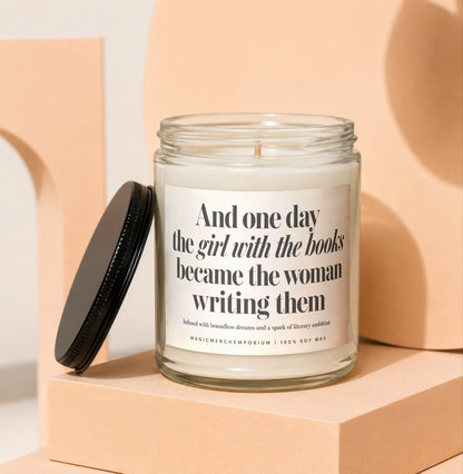 Glass candle with "And one day the girl with the books became the woman writing them" text.