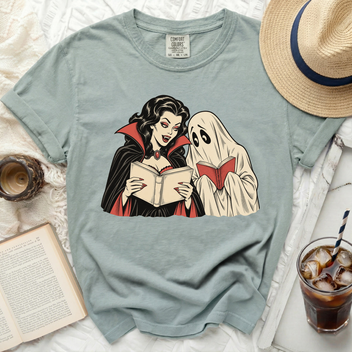 Vampire and ghost reading books on a light blue t-shirt with Comfort Colors tag.