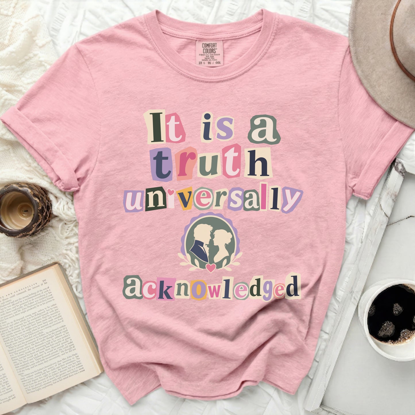 Pink t-shirt with "It is a truth universally acknowledged" text and couple silhouette.