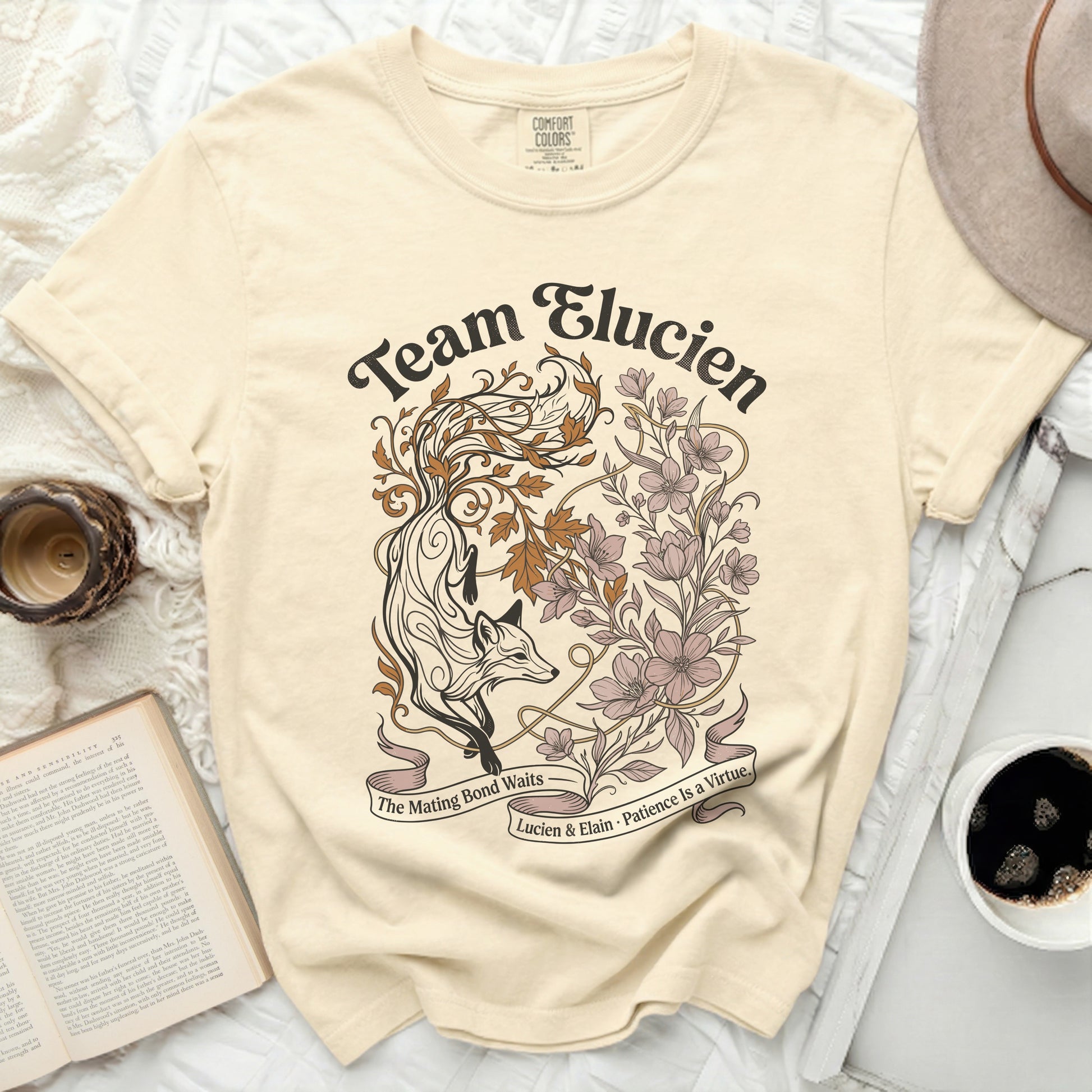 Cream t-shirt with "Team Elucien" fox and floral graphic.