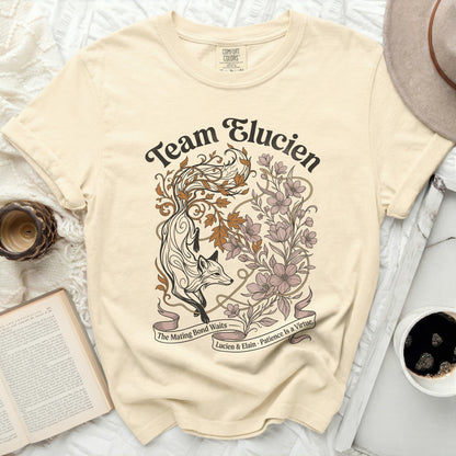 Cream t-shirt with "Team Elucien" fox and floral graphic.