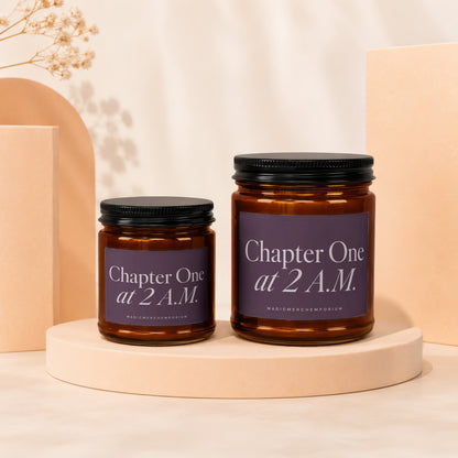 Two amber glass candles with black lids and purple labels reading "Chapter One at 2 A.M."