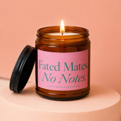 Amber jar candle with lit wick, pink label reads "Fated Mates. No Notes."