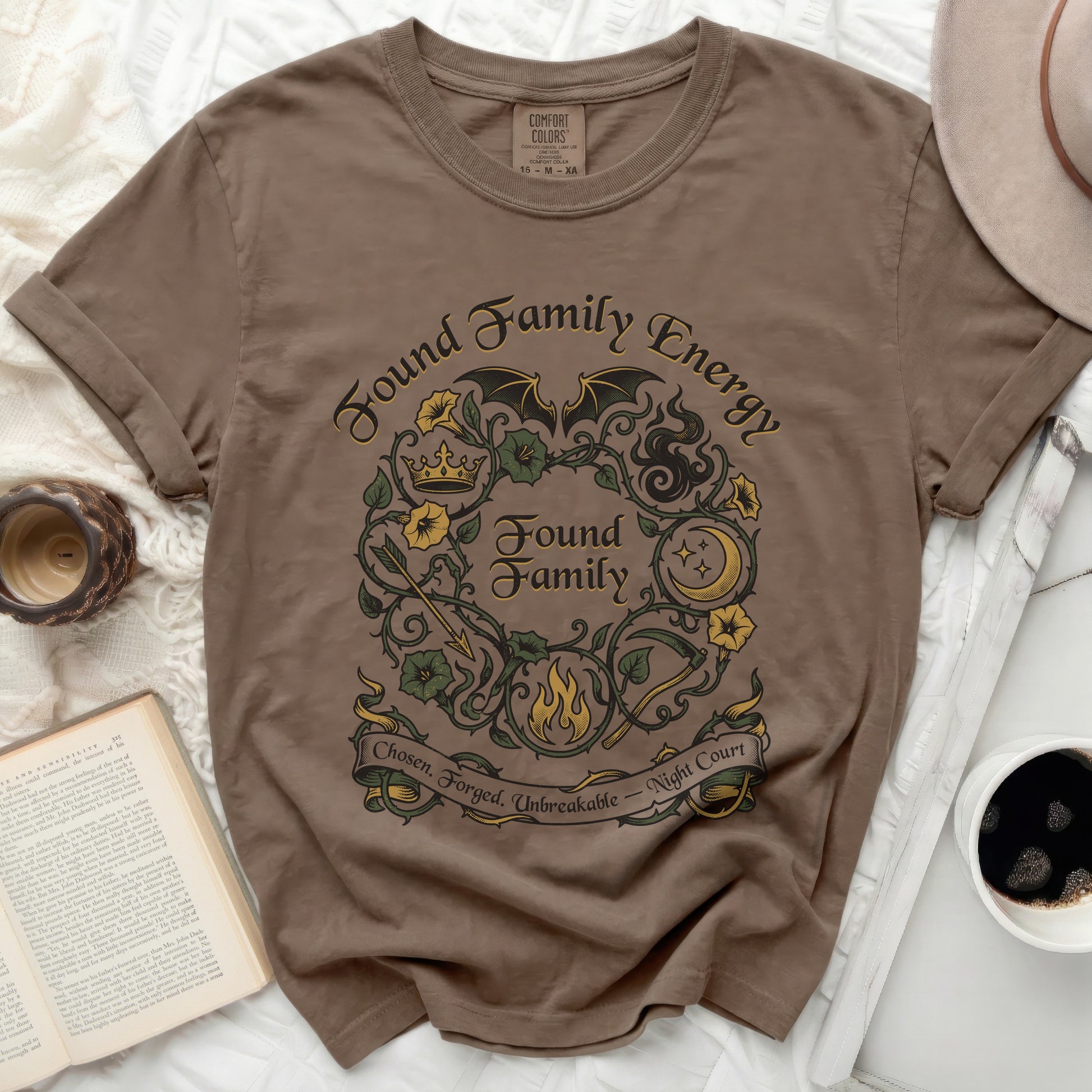 Brown t-shirt with "Found Family Energy Found Family Chosen. Forged. Unbreakable" text.