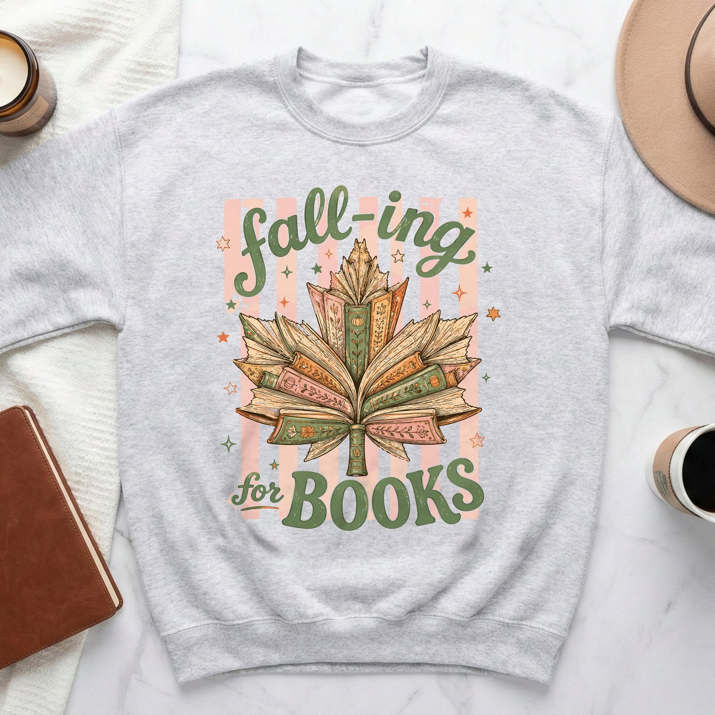 Grey sweatshirt with a leaf made of open books and text "fall-ing for BOOKS".