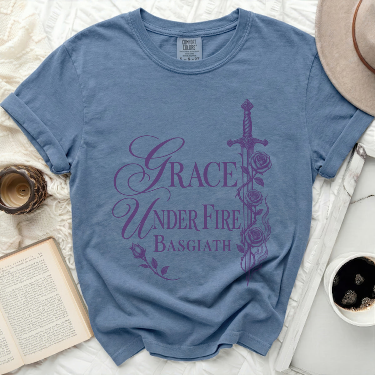 Blue t-shirt with purple "Grace Under Fire Basgiath" text and sword design.