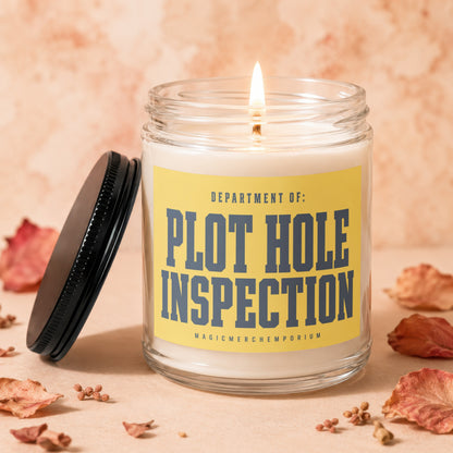 Lit glass candle with yellow label stating "Department of: Plot Hole Inspection".