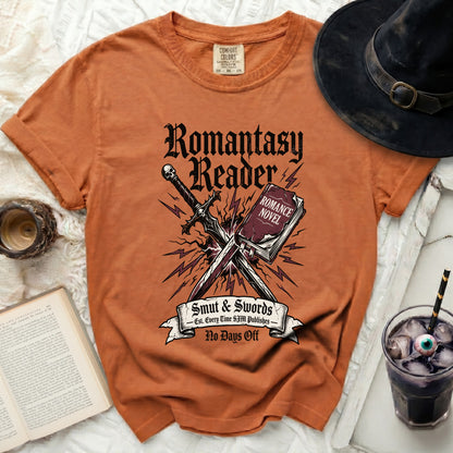 Orange t-shirt with "Romantasy Reader," sword, book, and lightning bolt graphic.