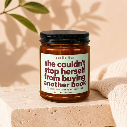 Candle with text "smells like she couldn't stop herself from buying another book."