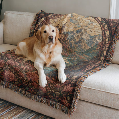 A golden retriever dog is lying on a couch, resting on a colorful, patterned blanket.