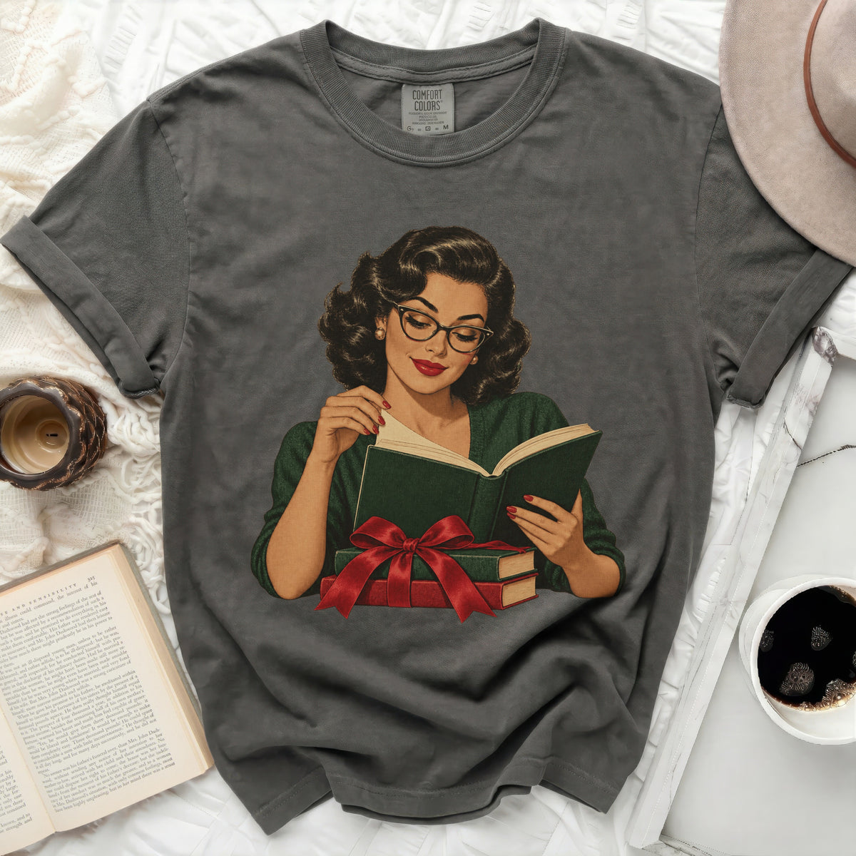 Vintage-style woman in glasses reading a book with a red ribbon, on a gray t-shirt.