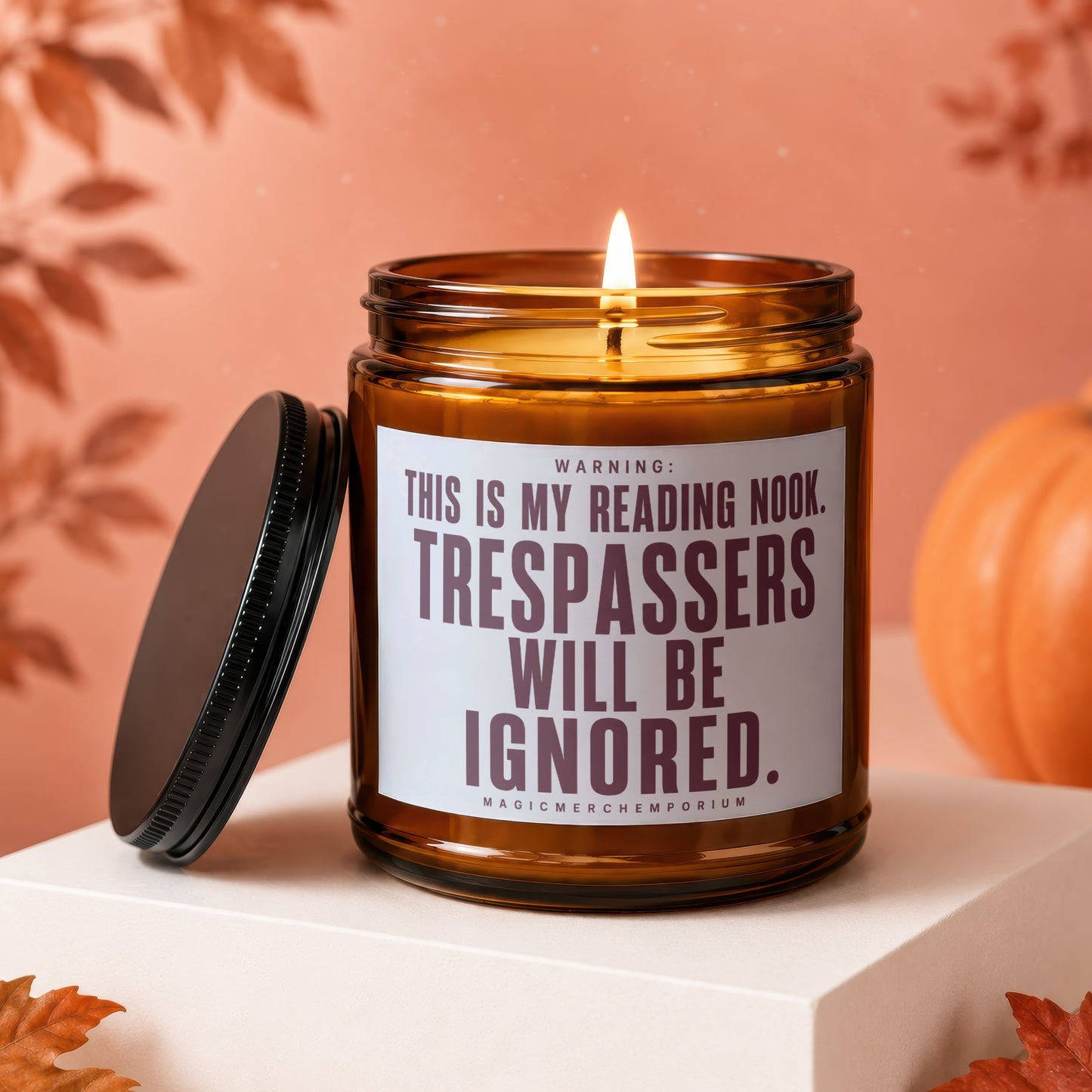 Amber glass candle with lid off, reading "WARNING: THIS IS MY READING NOOK. TRESPASSERS WILL BE IGNORED."