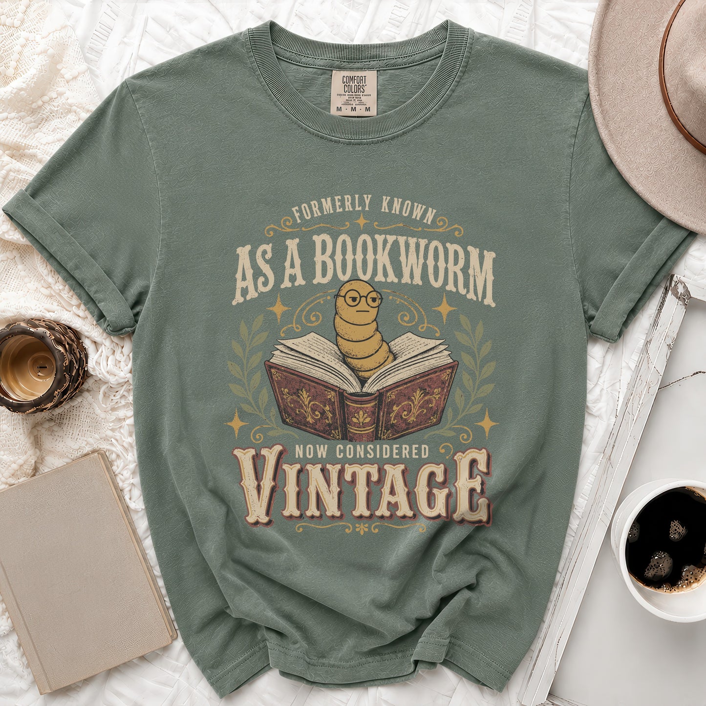 Green t-shirt with a worm in glasses on an open book, text reads "Formerly Known As A Bookworm Now Considered Vintage".