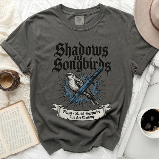 Dark grey t-shirt with "Shadows and Songbirds" and sword design.